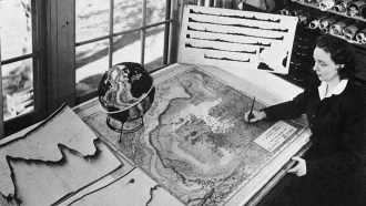 Marie Tharp looks over a map on a table