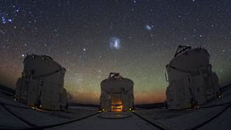 A photo of part of the Paranal Observatory in Chile with the Large Magellanic Cloud visible in the center and Small Magellanic Cloud visible on the right.