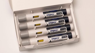 An image shows four Wegovy injector pens lying in a white cardboard box.